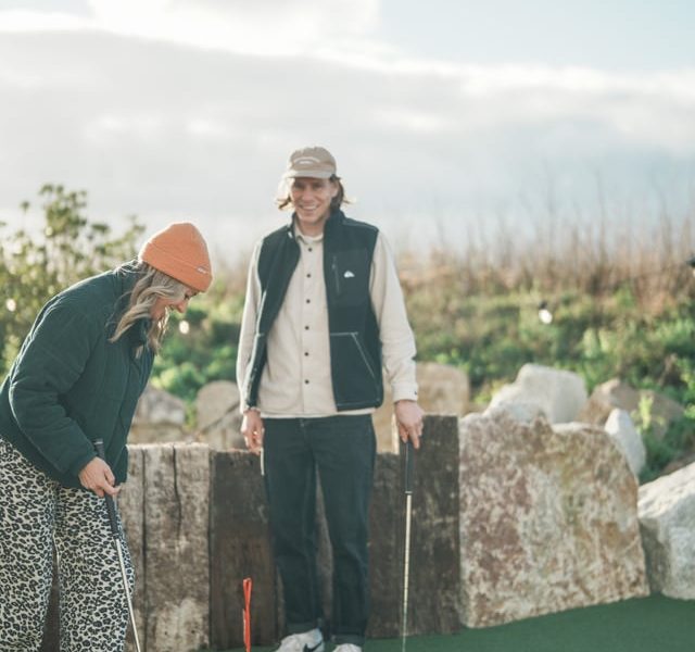 Two people playing mini golf
